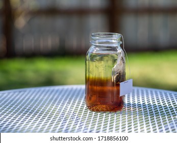 Brewing Sun Tea Or Sweet Tea In A Mason Jar Outdoors On A Warm Summer Day