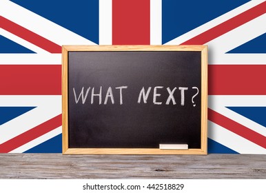 Brexit UK EU Referendum Concept For Out Of Great Britain From Rest European Union And Handwriting Text What Next Written In Chalkboard With Chalk On Flag, Close Up