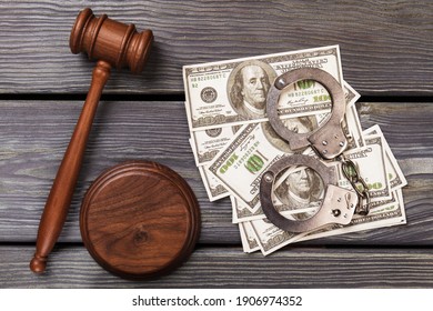 Bribe and corruption concept. Top view us dollars money with handcuffs and wooden gavel.