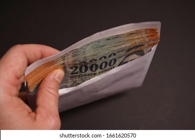 Bribe money in the envelope. Hungarian forint banknote as background. - Shutterstock ID 1661620570