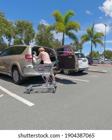 BRIBIE ISLAND, AUSTRALIA - Jan 22, 2021: A Woman Loading Groceries Into Her Car In The Supermarket Parking Lot On A Sunny Day