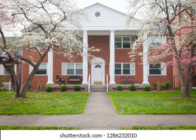 Brick Apartment Building With White Columns.