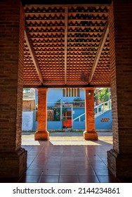 Brick Archway Leading To Red Door.