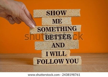 Brick blocks with text Show me something better and i will follow you. Beautiful orange background, wooden table, copy space. Positive Quote. Businessman hand. Stock photo © 