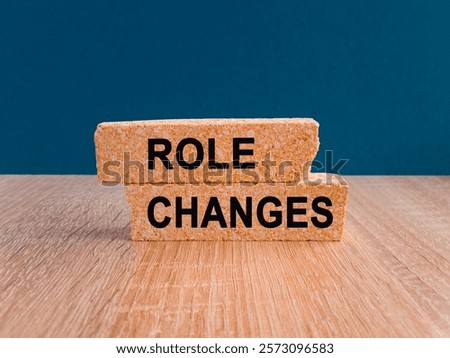 Brick blocks with words Role changes. Beautiful blue background, wooden table. Business and Role changes concept. Copy space.