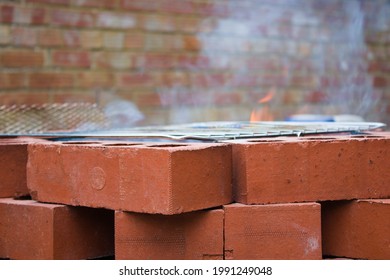 Brick Bon Fire Pit With Barbecue Mash On The Top, Flame, Smoke, Brick Wall Background, Close Up