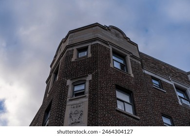 Brick building corner under a cloudy sky.