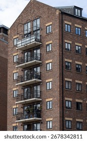 A brick building with multiple balconies and windows. The building is tall and rectangular with a pitched roof  in Newcastle upon Tyne, UK.