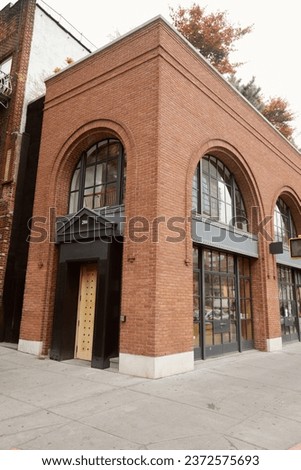 brick building with portico and arch window in downtown of new york city, urban architecture