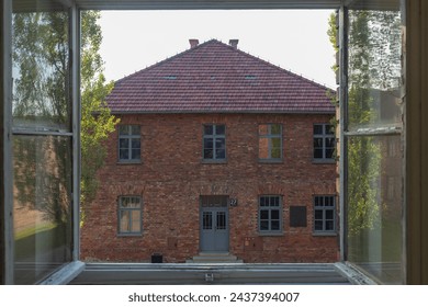 brick building seen through the opened window in auschwitz memorial museum in the evening