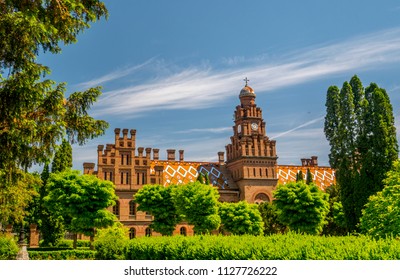 brick building of the university against the background of blue sky and green trees - Shutterstock ID 1127726222