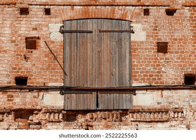 A brick building with a wooden door. The door is wooden and has a metal hinge - Powered by Shutterstock