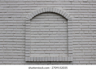 A brick built archway protruding from a solid white brick wall stock photo 