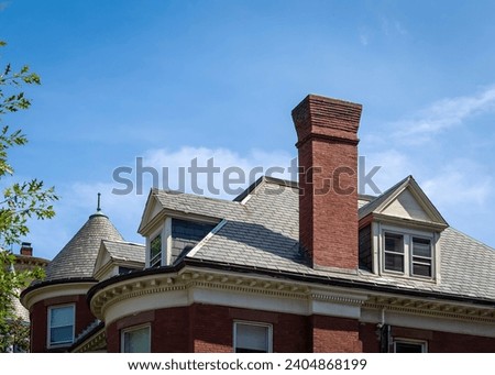 Brick chimney and gabled dormer windows of a house in a sunny day, Brookline, MA, USA