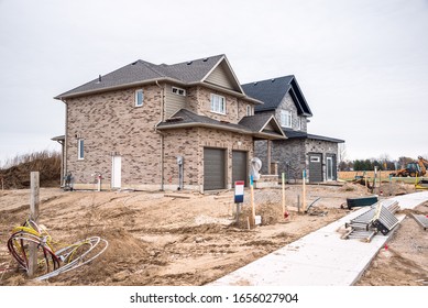 Brick Detached houses in construction in a housing development in Ontario, Canada, on a cloudy fall day