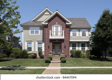 Brick Home With Beige Siding And Front Balcony