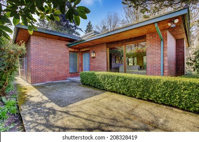 Brick House Entrance Porch With Walkway And Trimmed Hedges Alongside