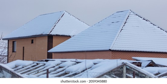 Brick House With Snow On The Roof In Winter.