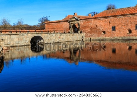 Brick stone bridge across the lake surrounding Frederiksborg castle in Hillerod, near Copenhagen, Denmark