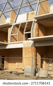 brick structure with steel frame and triangular roof bays illuminated by late sunlight exposed blockwork, metal connectors