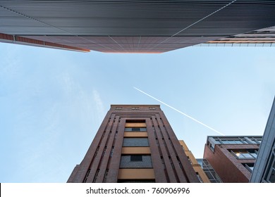 Brick Tower and Building Complex under a blue Sky, with a Jet Trail across