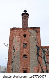 Brick Tower Of An Old House With Vintage Windows. Some With Broken Glasses. Red Brick House.