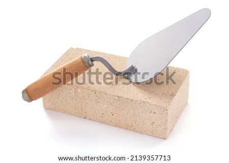 Brick and trowel tool isolated on white background. Construction brick with mason at white