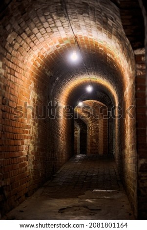Brick tunnel in old German fort, red brick loft corridor with old wiring, industrial basement of secret military base. Secret passageway of old mansion. Fort No. 5 King Frederick William III