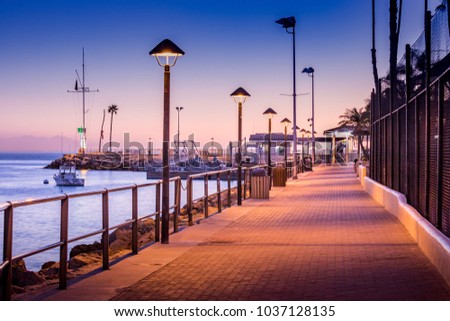 Brick walkway to boat dock in early morning sunrise light, streelights on, shadows, quiet, calm peaceful, Avalon, Santa Catalina Island, California
