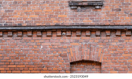 A brick wall with a camera on it. The camera is on the wall and is not visible