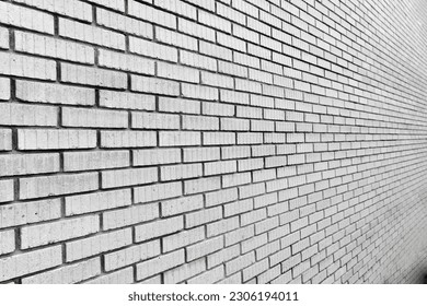 A brick wall constructed with sturdy, interlocking bricks, forming a timeless structure that adds strength, character, and charm to any space.