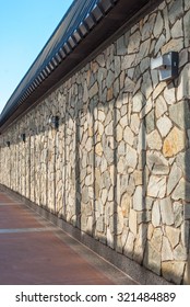 Brick wall facade with shadows. External building wall with shadows. Stone wall during daytime with shadows. Natural sunlight on stone wall. Abstract background. Architecture design. Modern art.