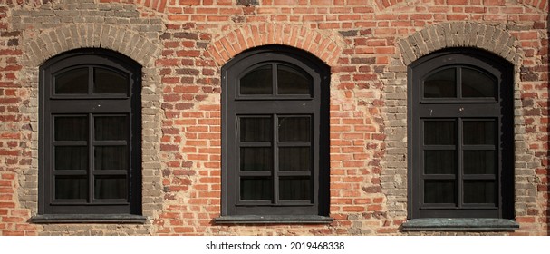 Brick Wall Of An Old Building With Arched Windows.