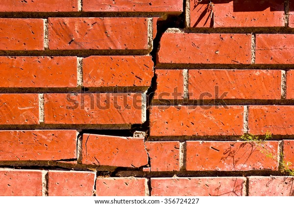 Brick\
wall old and run down, is crackdown in the\
middle.