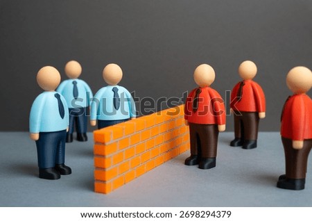 A brick wall separates two ideological camps of office workers. Two opposing teams or business departments. Competition, team disagreement, or workplace polarization.
