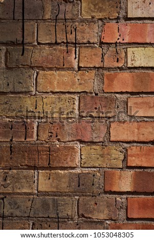 Brick wall with tar splatters and a little tiny bit of graffiti.  