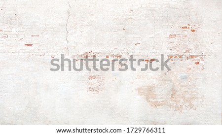 Brick wall texture with white shabby stucco, plaster. Red  and white brickwall background, white stonewall surface. Plastered wall with white uneven stucco with cracks and damages.