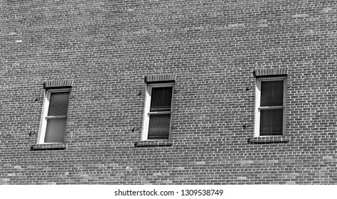 Brick wall with three windows abstract background.