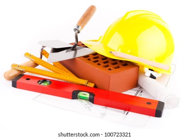 Brick, Yellow Hard Hat, Tools And Construction Plans Isolated On White Background