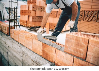 Bricklayer Industrial Worker Installing Brick Masonry On Exterior Wall With Trowel Putty Knife