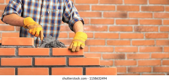 Bricklayer industrial worker installing brick masonry - Shutterstock ID 1158632494
