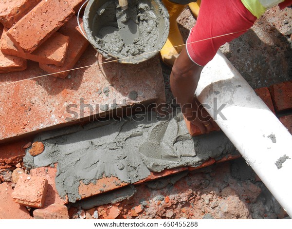 Bricklayer lay
clay bricks block and stacked it together using cement mortar to
form walls at the construction site.
