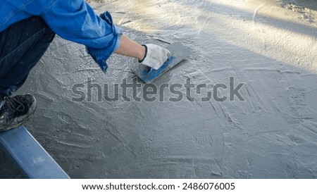Bricklayer laying concrete To create a cement floor inside the house, soft focus