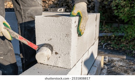 Bricklayer putting down another row of bricks in site