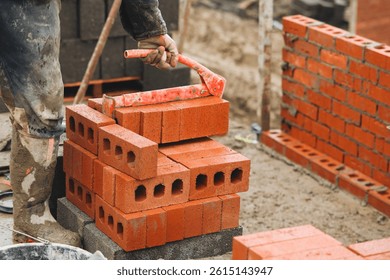 Bricklayer stacking bricks during building project at construction site in the afternoon, showcasing the labor and craftsmanship involved in masonry work
