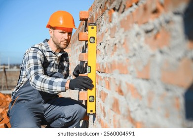 Bricklayer Using a Spirit Level to Check New Red Brick Wall Outdoor. Bricklaying Basics Masonry Techniques.