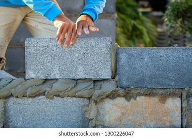 Bricklayer worker installing brick masonry on exterior wall - Shutterstock ID 1300226047