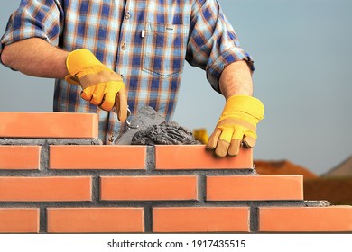 Bricklayer worker installing brick masonry - Shutterstock ID 1917435515