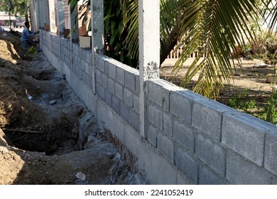 The bricks built between the pillars form the fence.