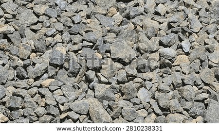 The bricks have a rough texture, angular shape, and are arranged tightly on the surface.